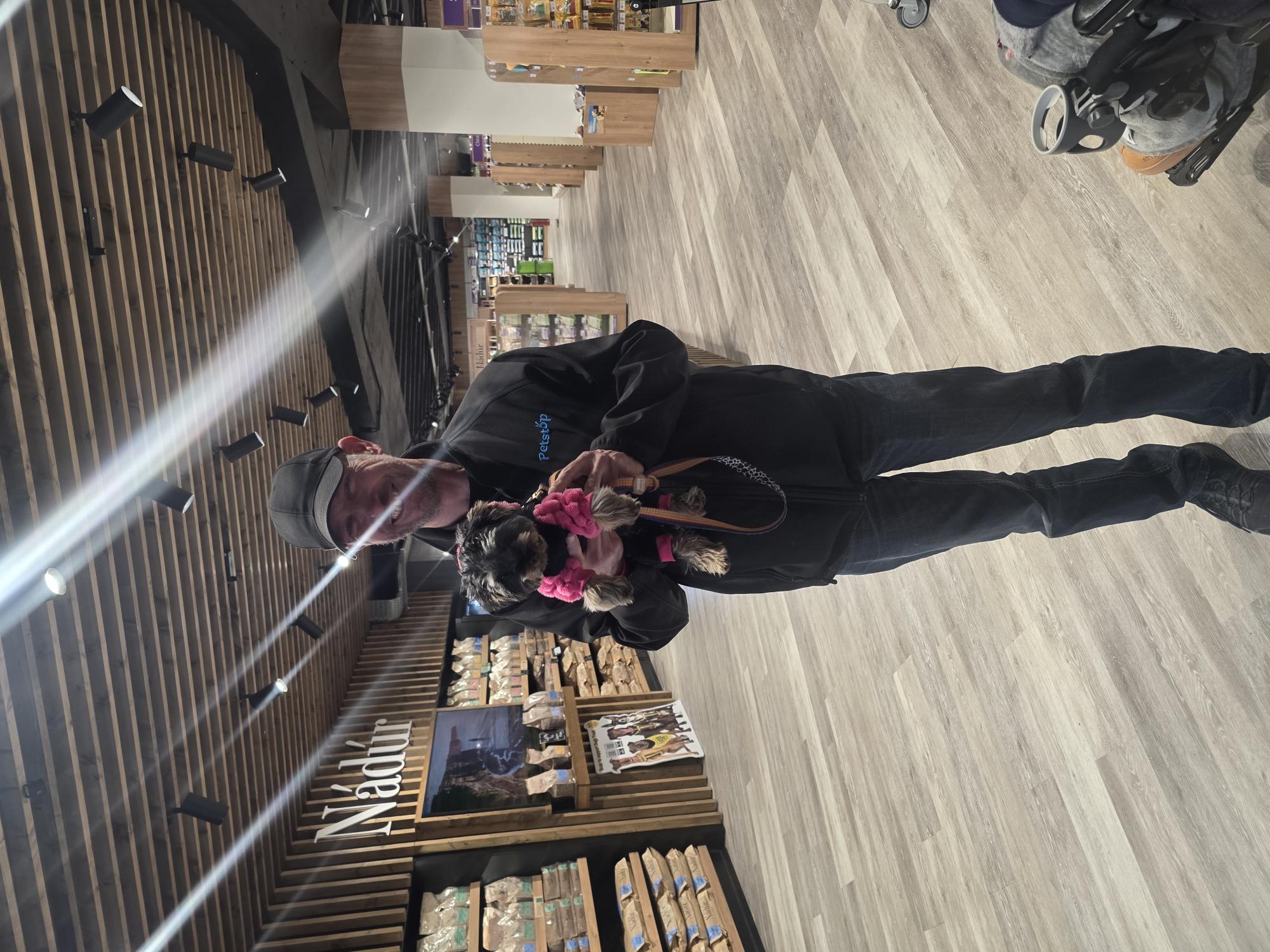 A Petstop team member on the shopfloor holding a customer puppy