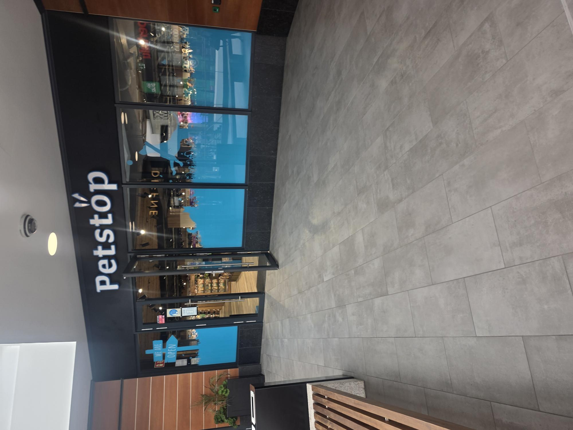 Petstop storefront in a shopping centre, with bright blue branding and a &lsquo;We Are Open&rsquo; signpost
